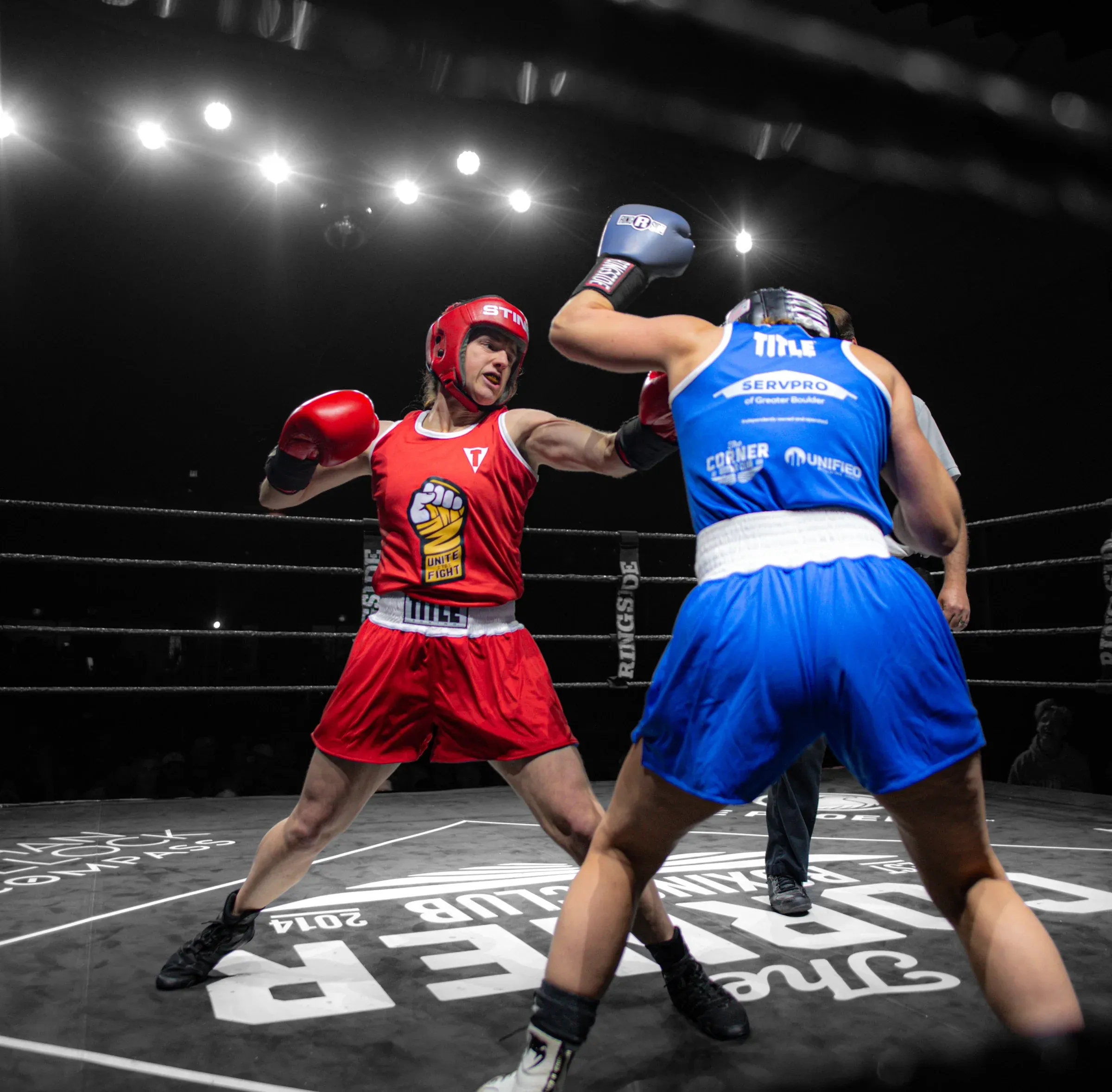 Two amateur boxers in a sanctioned bout under the lights