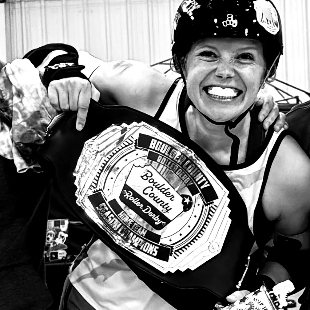 A smiling boxer holding up a championship belt